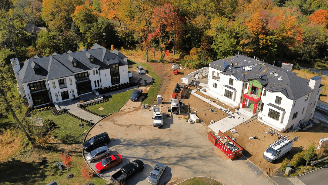 Aerial view of a custom home at dusk with a private lake